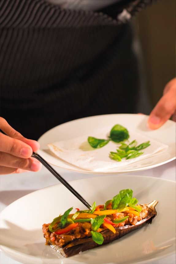 A chef plating a dish in the kitchen at The Balgarth Pines